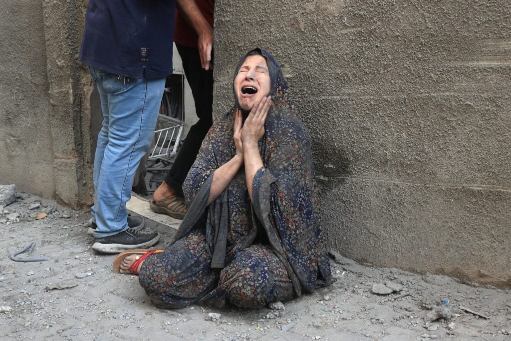 A Palestinian woman reacts after an Israeli airstrike on the Rafah refugee camp, in the southern Gaza Strip on October 17, 2023. Relief convoys which have been waiting for days in Egypt were on October 17, headed towards the Rafah border crossing with the besieged Palestinian enclave of Gaza, aid officials said.