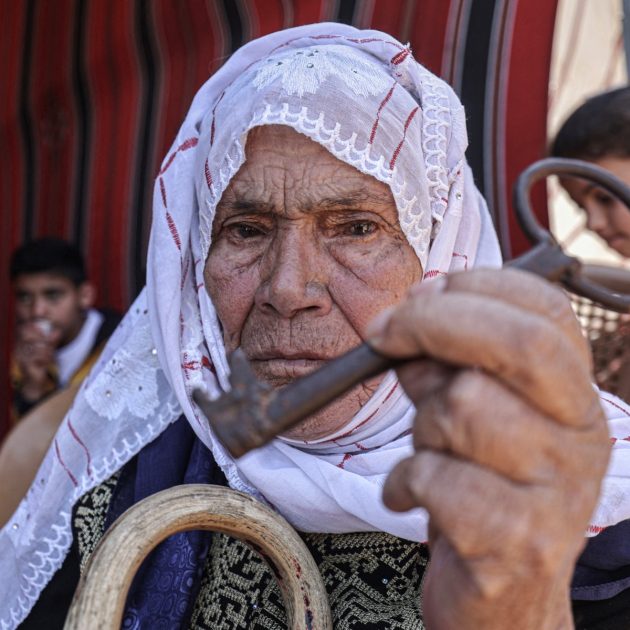 A woman holds a key symbolising the homes left by Palestinians in 1948, during a rally along the border east of Khan Yunis in the southern Gaza Strip on May 1, 2023 marking the 75th anniversary of the Nakba. The event is known by Palestinians as the Nakba, or "catastrophe", during which more than 600 communities were destroyed or depopulated by Jewish forces, according to the Israeli organisation Zochrot. The memory of the Nakba, which is commemorated on May 15, has become a rallying point for the Palestinian quest for statehood. (Photo by SAID KHATIB / AFP)