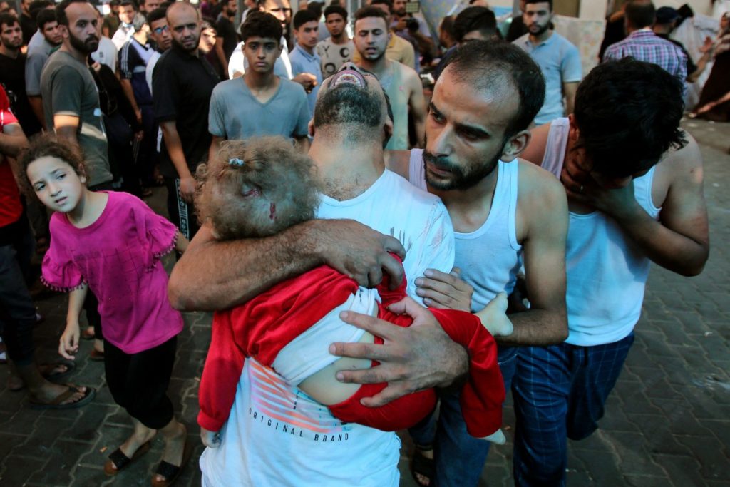 A man reacts as he carries a toddler into the Al-Shifa Hospital following the bombing by the Israeli military of a home in Gaza City's Mansura neighbourhood, in the eastern suburb of Shujaiya on November 4, 2023, amid the ongoing battles between Israel and the Palestinian group Hamas. - Thousands of civilians, both Palestinians and Israelis, have died since October 7, 2023, after Palestinian Hamas militants based in the Gaza Strip entered southern Israel in an unprecedented attack triggering a war declared by Israel on Hamas with retaliatory bombings on Gaza. (Photo by Bashar TALEB / AFP)