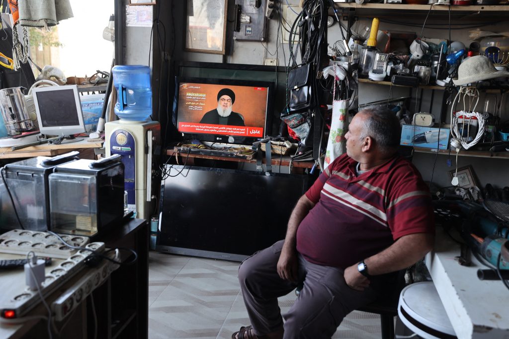 A man sitting in a shop watches the televised speech of Lebanon's Hezbollah chief Hasan Nasrallah, in the occupied West Bank town of Tubas on November 3, 2023. - Nasrallah on November 3 spoke for the first time since war broke out between Hamas and Israel, in a speech that could impact the region as the Gaza conflict rages. (Photo by Jaafar ASHTIYEH / AFP)