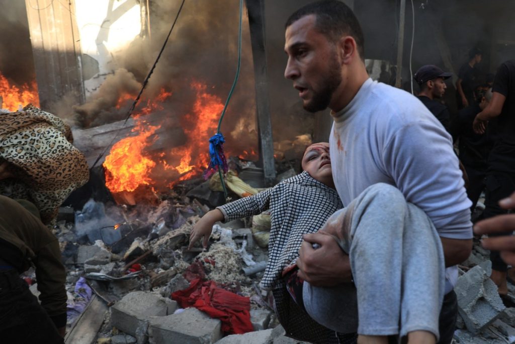 A man evacuates a wounded girl after Israeli bombardment in Rafah in the southern Gaza Strip on November 17, 2023, amid ongoing battles between Israel and the Palestinian group Hamas. (Photo by SAID KHATIB / AFP)