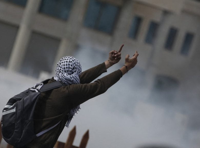 A Palestinian stone thrower gives the finger during clashes with Israeli security forces in Beit El Jewish settlement, north of Ramallah, in the occupied West Bank, on October 8, 2015. There have been at least eight stabbing attacks since the beginning of the month, when a Palestinian killed two Israelis in Jerusalem's Old City, helping to prompt a security crackdown and spread riots. AFP PHOTO / ABBAS MOMANI (Photo by ABBAS MOMANI / AFP)
