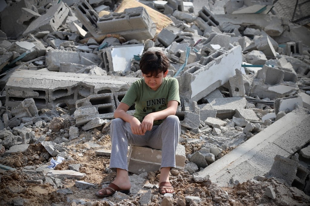 10/08/2023 Gaza, Palestine. A Palestinian child boy next to the ruins of a building in Gaza City that was hit by a rocket. Israel has initiated a conflict with Hamas, launching retaliatory strikes, while Hamas claims that its attacks mark just the start of what they perceive as a prolonged battle. According to Israeli authorities, the confirmed casualties have exceeded 700 Israelis. In Gaza City, on October 8, 2023, Palestinians stand amid the wreckage of buildings destroyed by an Israeli airstrike. (Photo by Doaa Albaz / Middle East Images / Middle East Images via AFP)