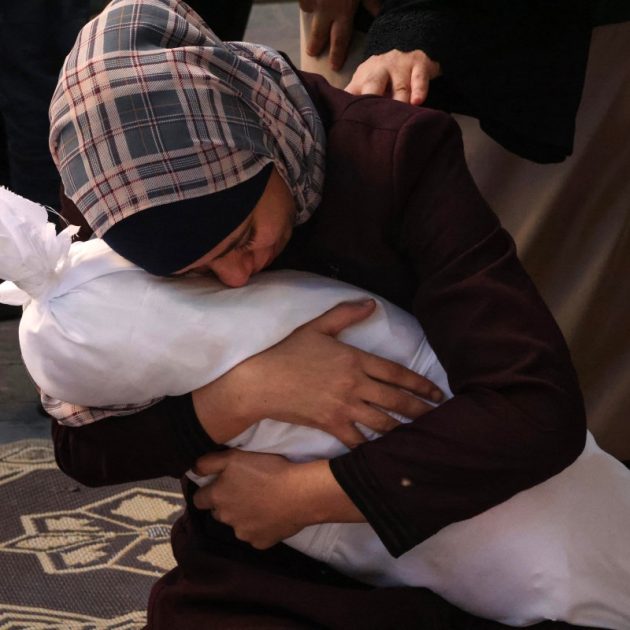 Palestinian Samia al-Atrash holds the corpse of one of her sister's children from the Khoder family, killed in an Israeli bombardment in Rafah in the southern Gaza Strip on October 21, 2023. - Thousands of people, both Israeli and Palestinians have died since October 7, 2023, after Palestinian Hamas militants based in the Gaza Strip, entered southern Israel in a surprise attack leading Israel to declare war on Hamas in Gaza on October 8. (Photo by SAID KHATIB / AFP)