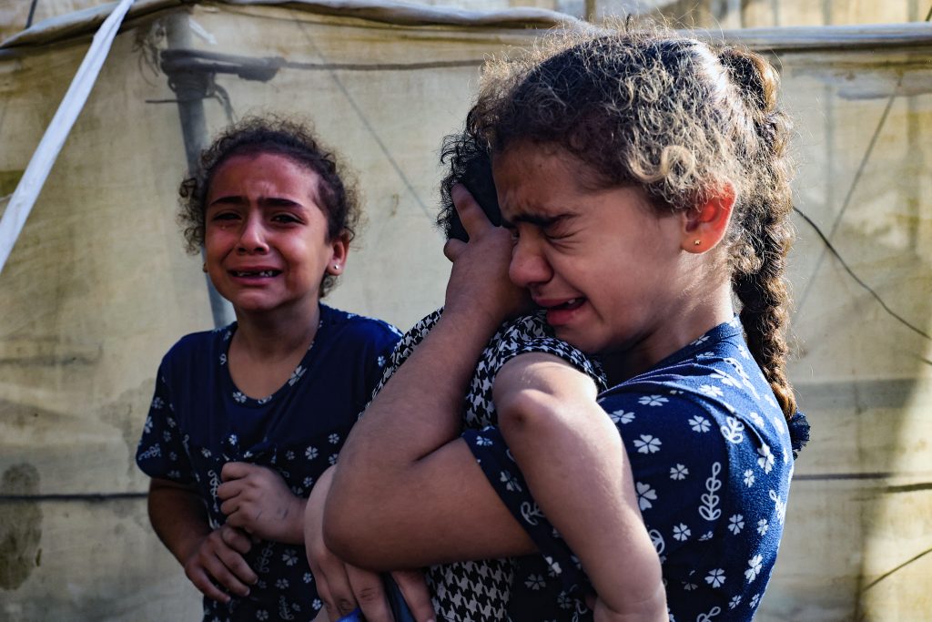 Children react during the funeral of the Faojo family, killed in Israeli bombing on Rafah in the southern Gaza Strip on November 11, 2023, as battles between Israel and the Palestinian Hamas movement continue. (Photo by SAID KHATIB / AFP)