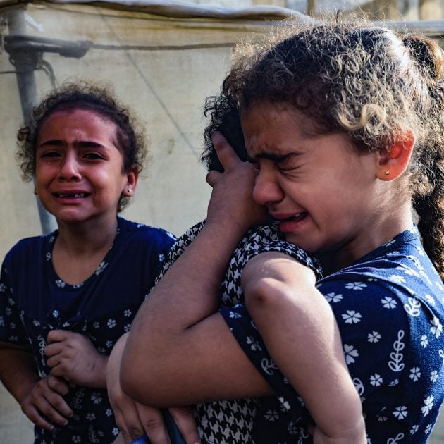 Children react during the funeral of the Faojo family, killed in Israeli bombing on Rafah in the southern Gaza Strip on November 11, 2023, as battles between Israel and the Palestinian Hamas movement continue. (Photo by SAID KHATIB / AFP)