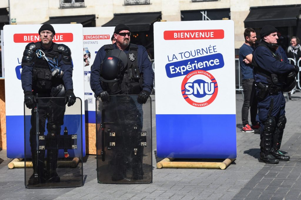 French police officers stand by a promotional campaign village for the Universal National Service, or SNU (Service National Universel), in Nantes, Western France, on April 19, 2023. (Photo by Sebastien SALOM-GOMIS / AFP)