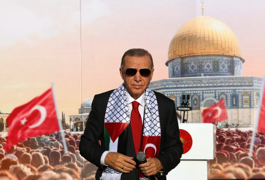 Turkish President Tayyip Erdogan, wearing a scarf with the Palestinian and Turkish flags, stands on the stage during a rally organised by the AKP party in solidarity with the Palestinians in Gaza, in Istanbul on October 28, 2023. - Erdogan's Islamic-rooted party staged a massive pro-Palestinian rally in Istanbul on October 28, 2023 that the Turkish leader said had drawn a crowd of 1.5 million. He unleashed a scathing attack at Israel and its Western supporters after taking the stage with a microphone in his hand. "The main culprit behind the massacre unfolding in Gaza is the West," Erdogan told the Turkish and Palestinian flag-waving crowd. (Photo by HANDOUT / TURKISH PRESIDENCY PRESS OFFICE / AFP) / RESTRICTED TO EDITORIAL USE - MANDATORY CREDIT "AFP PHOTO / TURKISH PRESIDENCY PRESS OFFICE " - NO MARKETING NO ADVERTISING CAMPAIGNS - DISTRIBUTED AS A SERVICE TO CLIENTS - RESTRICTED TO EDITORIAL USE - MANDATORY CREDIT "AFP PHOTO / Turkish Presidency press office " - NO MARKETING NO ADVERTISING CAMPAIGNS - DISTRIBUTED AS A SERVICE TO CLIENTS /
