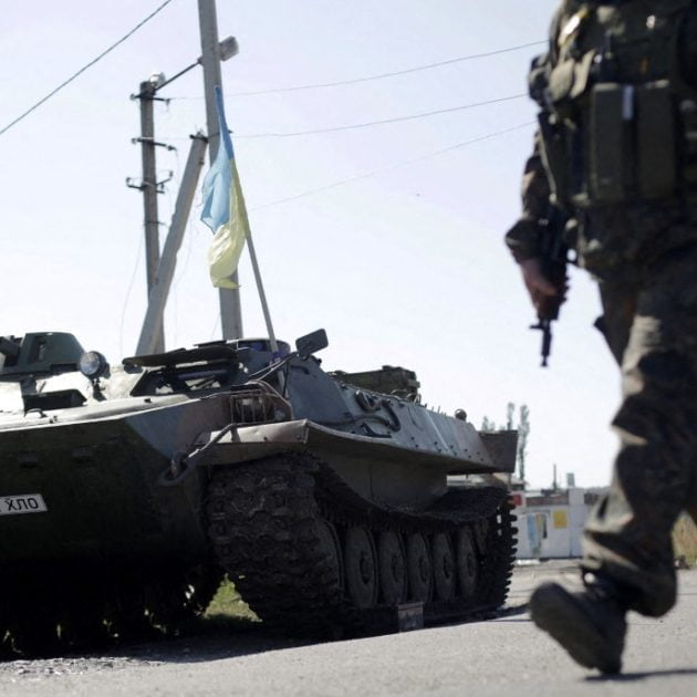 An Ukrainian serviceman walks past an armoured personnel carrier (APC) at a checkpoint in Karlovka, some 30 km northwest of Donetsk, eastern Ukraine, on September 6, 2014, a day after Kiev and pro-Russian rebels signed a ceasefire after five months conflict, which has plunged relations between Russia and the West into their worst crisis since the Cold War. Pro-Russian rebels and the Ukrainian military accused each other on September 6 of breaking a tenuous Kremlin-backed truce only hours after it came into force at 1500 GMT on September 5 across the war-battered east. But Ukrainian President Petro Poroshenko said on September 6 that he and Russian leader Vladimir Putin had agreed that the ceasefire between Kiev and separatist rebels was largely holding. AFP PHOTO / ANATOLII STEPANOV (Photo by ANATOLII STEPANOV / AFP)