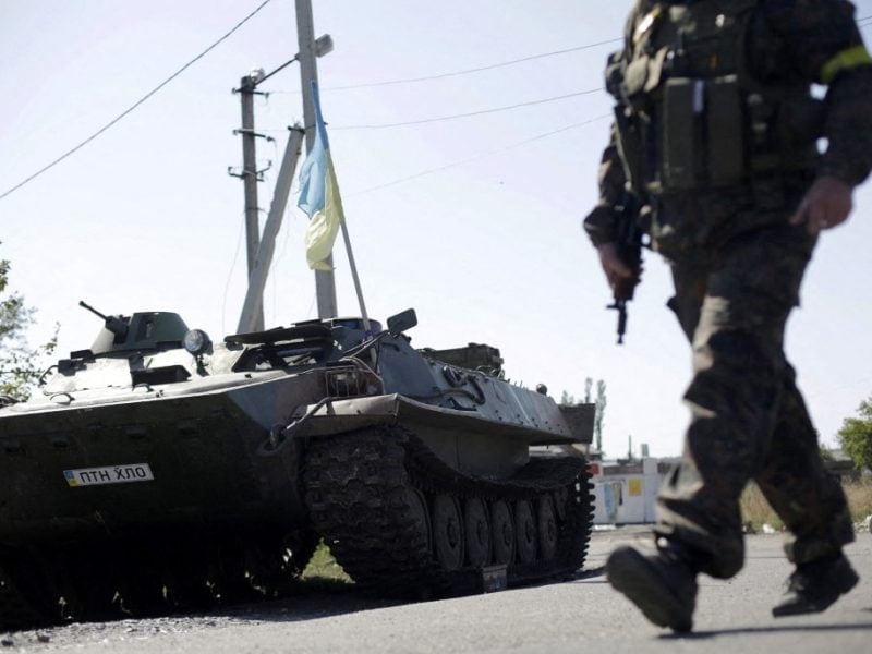 An Ukrainian serviceman walks past an armoured personnel carrier (APC) at a checkpoint in Karlovka, some 30 km northwest of Donetsk, eastern Ukraine, on September 6, 2014, a day after Kiev and pro-Russian rebels signed a ceasefire after five months conflict, which has plunged relations between Russia and the West into their worst crisis since the Cold War. Pro-Russian rebels and the Ukrainian military accused each other on September 6 of breaking a tenuous Kremlin-backed truce only hours after it came into force at 1500 GMT on September 5 across the war-battered east. But Ukrainian President Petro Poroshenko said on September 6 that he and Russian leader Vladimir Putin had agreed that the ceasefire between Kiev and separatist rebels was largely holding. AFP PHOTO / ANATOLII STEPANOV (Photo by ANATOLII STEPANOV / AFP)