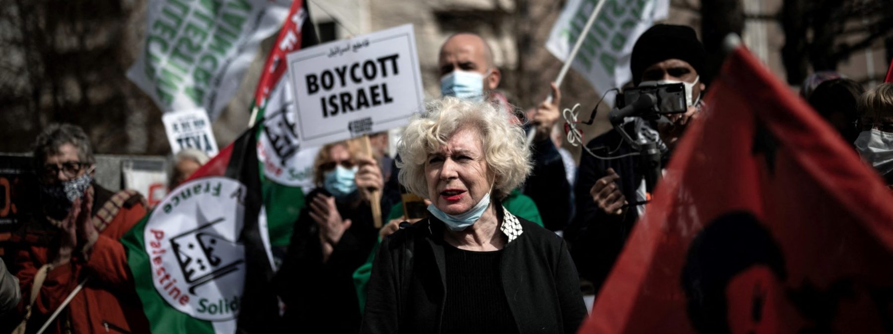 French political activist and director of publication of the Europalestine site Olivia Zemor takes part in a demonstration in front of Lyon's courthouse before attending her trial against Israeli pharmaceutical company TEVA on March 16, 2021. Olivia Zemor was summoned on March 16, 2021 in front the Lyon Criminal Court by the Israeli pharmaceutical company TEVA for having relayed a call for a boycott launched by activists of the Palestinian cause. She had reported, on her website, about the action that pro-Palestinian activists from Lyon took in front of the largest pharmacy in the city. An action that was part of the BDS movement ("boycott, divestment and sanctions"), a global campaign of economic, cultural or scientific boycott of Israel, aimed at obtaining the end of the Israeli occupation and colonisation of the Palestinians Territories . (Photo by JEFF PACHOUD / AFP)