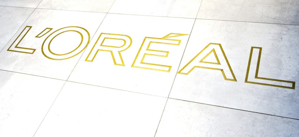 This photograph taken at the French cosmetic company 'L'Oreal' on November 17, 2022, shows the logo of L'Oreal on the floor at its production centre in Ormes, central France. (Photo by GUILLAUME SOUVANT / AFP)