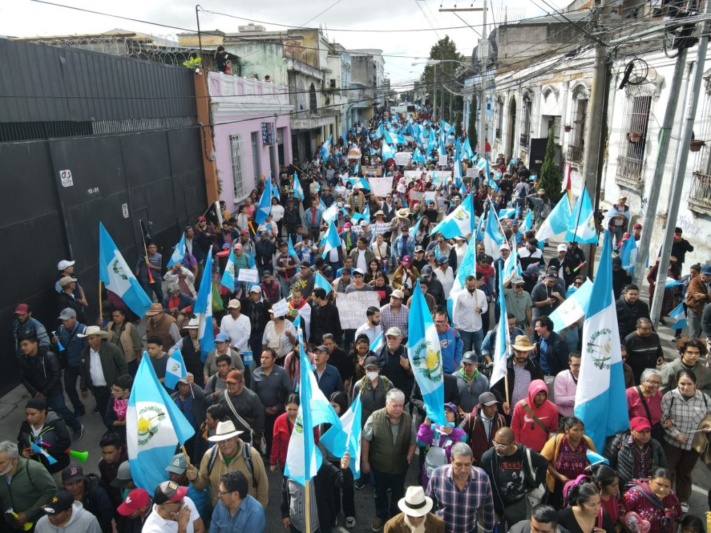Aerial view of people taking part in the "March for Democracy" to demand the resignation of Attorney General Consuelo Porras and prosecutor Rafael Curruchiche, accused of generating an electoral crisis, in Guatemala City on December 7, 2023. - Attorney General since 2018, Consuelo Porras went from having a discreet judicial career to being at the center of the political tension that Guatemala is experiencing, accused of being the architect of an offensive to prevent the elected president, Bernardo Arevalo, from assuming power in January. (Photo by Carlos ALONZO / AFP)