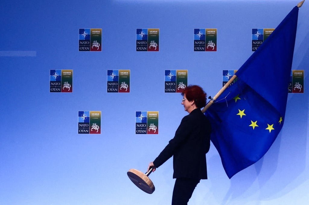 A woman carries EU flag during NATO Summit at LITEXPO Lithuanian Exhibition and Congress Center in Vilnius, Lithuania on July 12, 2023. (Photo by Beata Zawrzel/NurPhoto) (Photo by Beata Zawrzel / NurPhoto / NurPhoto via AFP)