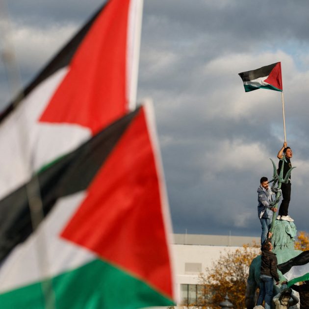 A demonstrator waves the Palestinian flag as he stands on the Neptune Fountain during a protest in support of Palestinians under the slogan 'Free Palestine' in Berlin, Germany on November 4, 2023. Thousands of civilians, both Palestinians and Israelis, have died since October 7, 2023, after Palestinian Hamas militants based in the Gaza Strip entered southern Israel in an unprecedented attack triggering a war declared by Israel on Hamas with retaliatory bombings on Gaza. (Photo by Odd ANDERSEN / AFP)