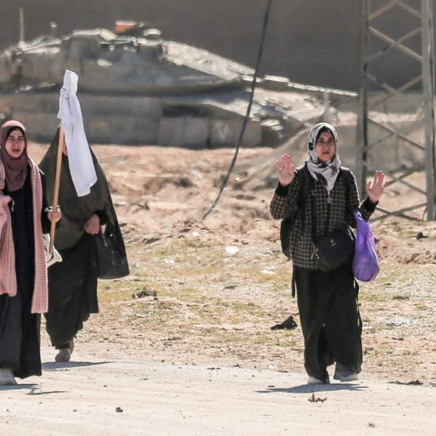 Displaced Palestinian women carrying their belongings lift a makeshift white flag as they walk past Israeli forces while fleeing the Hamad City area in Khan Yunis in the southern Gaza Strip on March 5, 2024, amid the ongoing conflict between Israel and the Hamas movement. (Photo by AFP)