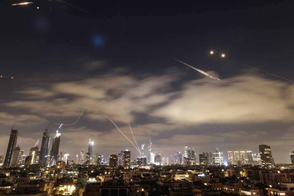 Israeli air defence systems are activated to intercept Iranian missiles over the Israeli city of Tel Aviv amid a fresh barrage of Iranian rockets on June 15, 2025. Israel and Iran traded heavy fire for a third straight day on June 15, with mounting casualties and expanding targets marking a sharp escalation in hostilities between the longtime foes. (Photo by Jalaa MAREY / AFP)