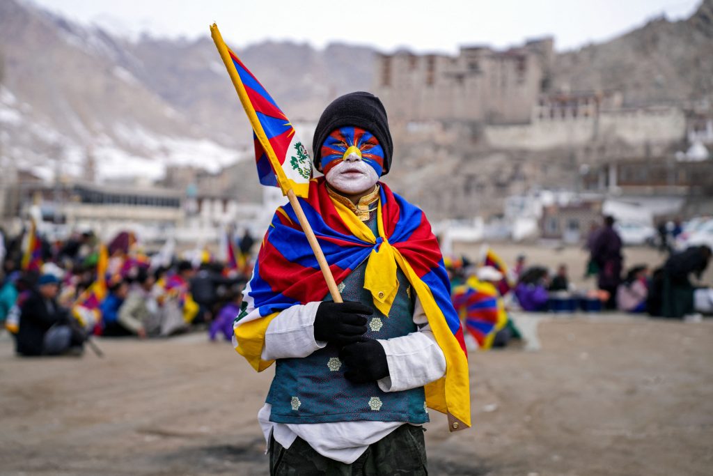 A youth with his face painted in the colours of the Tibetan flag takes part in a demonstration to mark Tibetan Women's Uprising Day to commemorate the 1959 revolt against Chinese occupation of Tibet, at the Polo Ground in Leh on March 12, 2025. (Photo by Mohd Arhaan ARCHER / AFP)