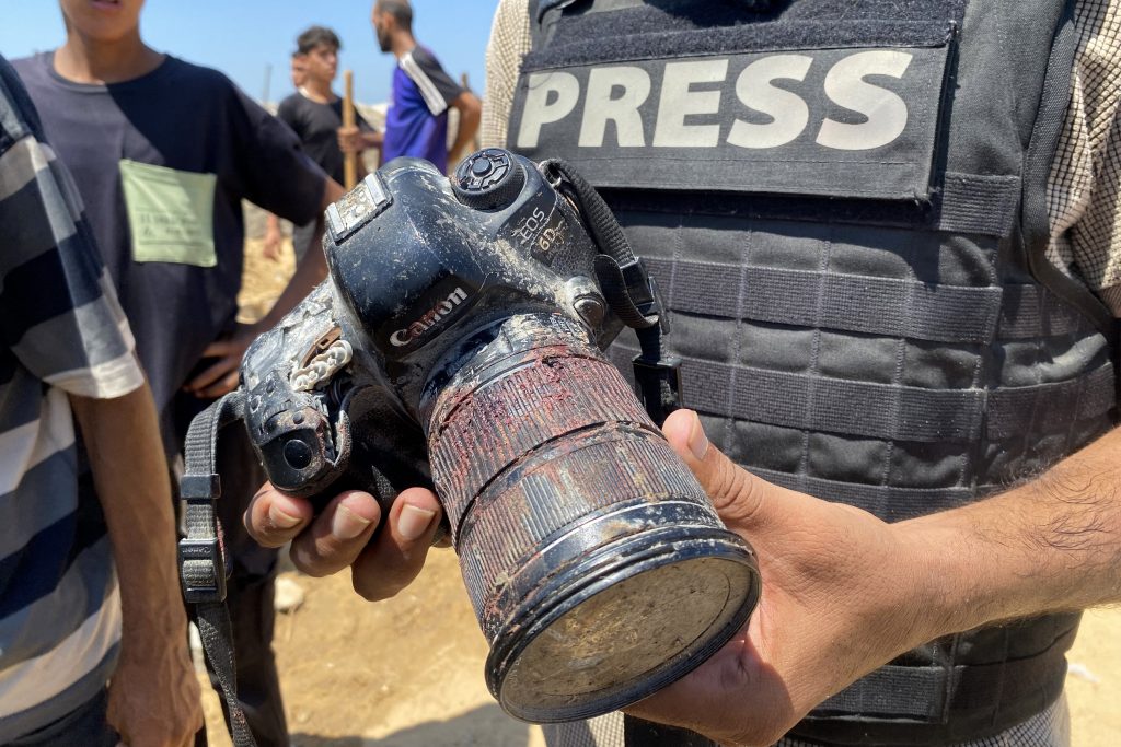 A journalist holds the blood-covered camera belonging to Palestinian photojournalist Mariam Dagga, a journalist who freelanced for AP since the start of the war and who was killed in an Israeli strike on Nasser hospital in Khan Yunis in the southern Gaza Strip, during her funeral on August 25, 2025. Gaza's civil defence agency said five journalists, including Mariam Dagga, were among at least 20 people killed on August 25 when Israeli strikes hit Nasser hospital in the south, with Reuters, the Associated Press and Al Jazeera mourning their slain contributors. (Photo by AFP) / The erroneous mention appearing in the caption of this photo by - has been modified in AFP systems in the following manner: [Palestinian photojournalist Mariam Dagga, a journalist who freelanced for AP since the start of the war] instead of [Palestinian photojournalist Hussam al-Masri, a Reuters contractor,]. Please immediately remove the erroneous mention from all your online services and delete it from your servers. If you have been authorized by AFP to distribute it to third parties, please ensure that the same actions are carried out by them. Failure to promptly comply with these instructions will entail liability on your part for any continued or post notification usage. Therefore we thank you very much for all your attention and prompt action. We are sorry for the inconvenience this notification may cause and remain at your disposal for any further information you may require.