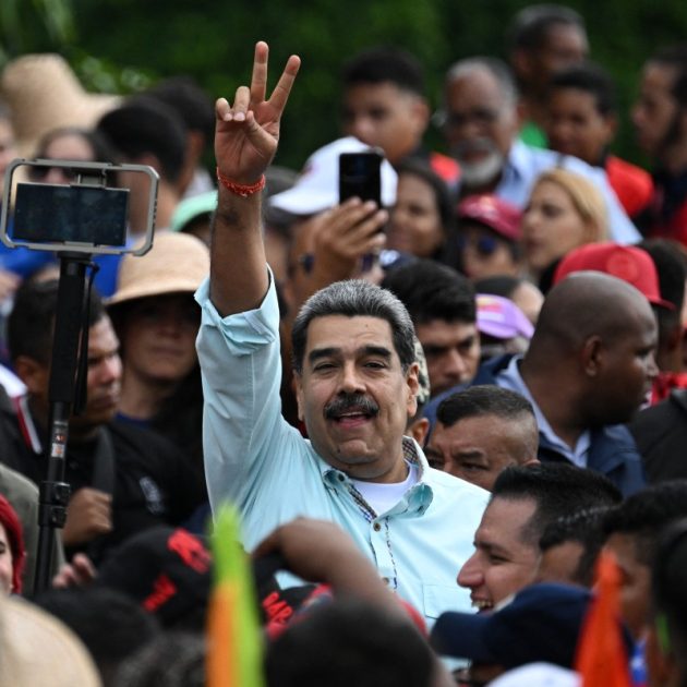 Venezuela's President Nicolas Maduro (C) greets supporters upon his arrival at a rally marking the anniversary of the Battle of Santa Ines, in Caracas on December 10, 2025. (Photo by Federico PARRA / AFP)
