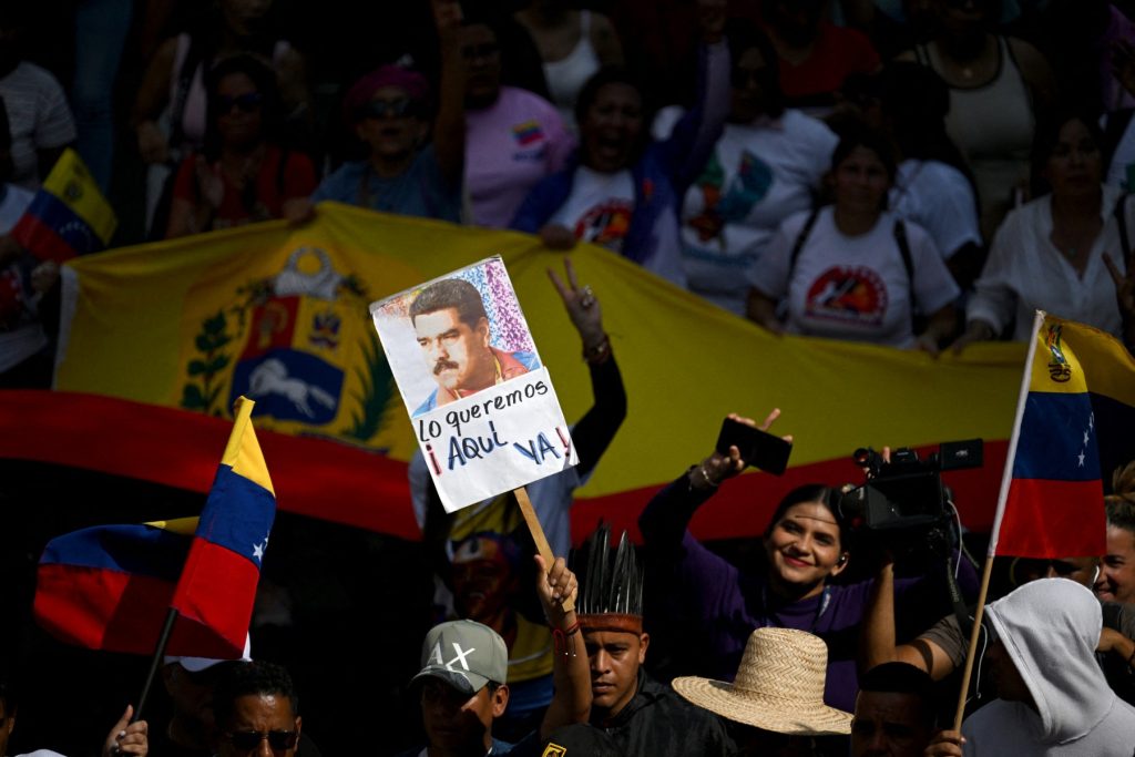 A demonstrator holds a picture of ousted Venezuela's President Nicolas Maduro during a rally to support him and his wife Cilia Flores in Caracas on January 6, 2026. US forces killed 55 Venezuelan and Cuban military personnel during their stunning raid to capture Nicolas Maduro, tolls published by Caracas and Havana showed on January 6. (Photo by Federico PARRA / AFP)
