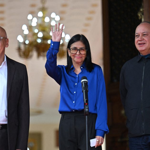 Venezuela's interim President Delcy Rodriguez (C) waves next to President of the National Assembly Jorge Rodriguez (L) and Minister of the Popular Power for Interior Diosdado Cabello after a press conference at the Miraflores Presidential Palace in Caracas on January 14, 2026. Venezuela's interim president Delcy Rodriguez said on January 14, that her country was looking to "a new political era" after the January 3 ouster of leader Nicolas Maduro in a US military strike. (Photo by Juan BARRETO / AFP)