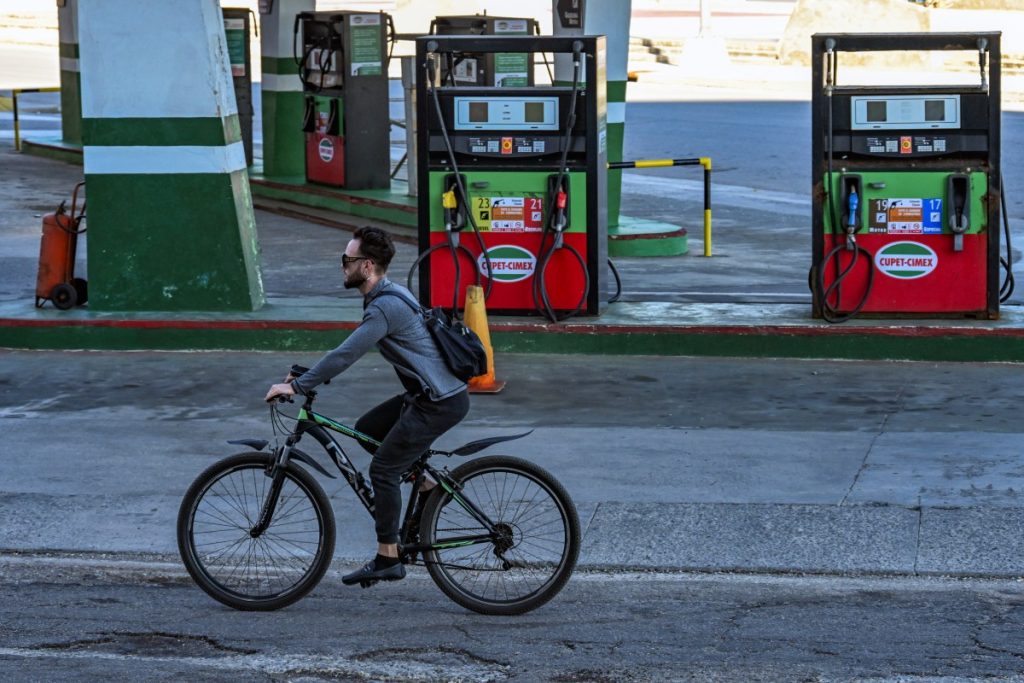 A man rides his bicycle past an empty gas station in Havana on February 19, 2026. Faced with a severe energy crisis exacerbated by US sanctions, private companies in Cuba are attempting to import fuel after the island's government agreed to end its monopoly on the sector. (Photo by YAMIL LAGE / AFP)
