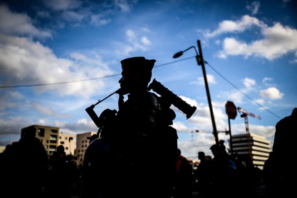 French gendarmes are pictured during a march in tribute to far-right activist Quentin Deranque, who died after being attacked on the sidelines of a far-right protest against a La France Insoumise (LFI) event at Sciences Po Lyon, in Lyon on February 21, 2026. (Photo by OLIVIER CHASSIGNOLE / AFP)