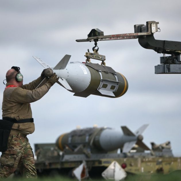 US Military personnel take away Joint Direct Attack Munitions (JDAMs), removed from a US Air Force B-1 Lancer bomber at RAF Fairford in south-west England on March 15, 2026. Fairford is one of two bases, along with the Diego Garcia facility in the Indian Ocean, that the UK has given the US permission to use for "specific defensive operations into Iran" to destroy Iranian missiles at source, the British defence minister said in a statement. (Photo by Henry NICHOLLS / AFP)