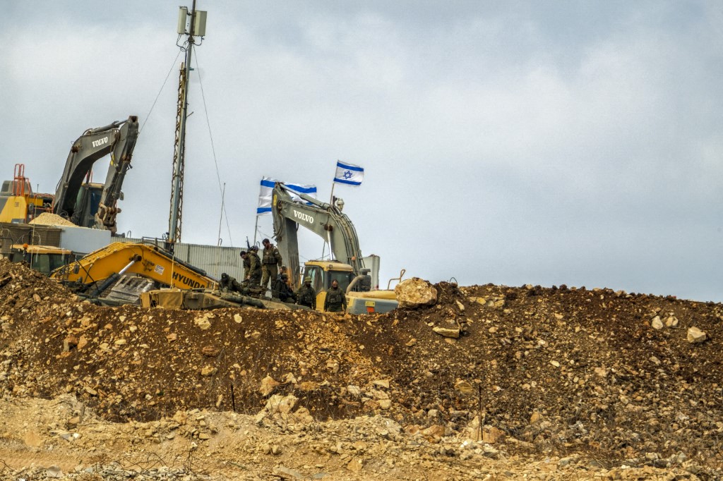 Israeli soldiers take a break from construction work at an illegal Israeli outpost in Houla, southern Lebanon, on July 31, 2025. Positioned directly adjacent to a United Nations facility, the site has seen ongoing expansion activity, including the presence of armored construction vehicles such as a Caterpillar D9 bulldozer. The outpost, which is not officially recognized and lies beyond Israels internationally accepted border, highlights escalating tensions along the Lebanon-Israel frontier. The expansion has drawn condemnation from Lebanese officials and concern from international observers over violations of sovereignty and proximity to UN infrastructure. The buildup underscores the fragile security situation in the area, where incidents along the Blue Line often spark diplomatic and military friction. (Photo by COURTNEY BONNEAU / Middle East Images via AFP)