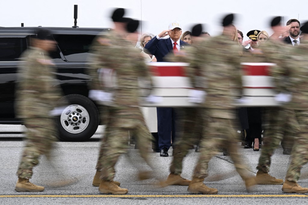 DOVER, DELAWARE - MARCH 07: (L-R) U.S. President Donald Trump and Vice President JD Vance salute as a U.S. Army carry team moves a flag-draped transfer case containing the remains of Sgt. 1st Class Nicole M. Amor at Dover Air Force Base March 07, 2026 in Dover, Delaware. Six soldiers from the 103rd Sustainment Command were killed in action by an Iranian drone strike on March 1 in Port Shuaiba, Kuwait during "Operation Epic Fury". Roberto Schmidt/Getty Images/AFP (Photo by ROBERTO SCHMIDT / GETTY IMAGES NORTH AMERICA / Getty Images via AFP)