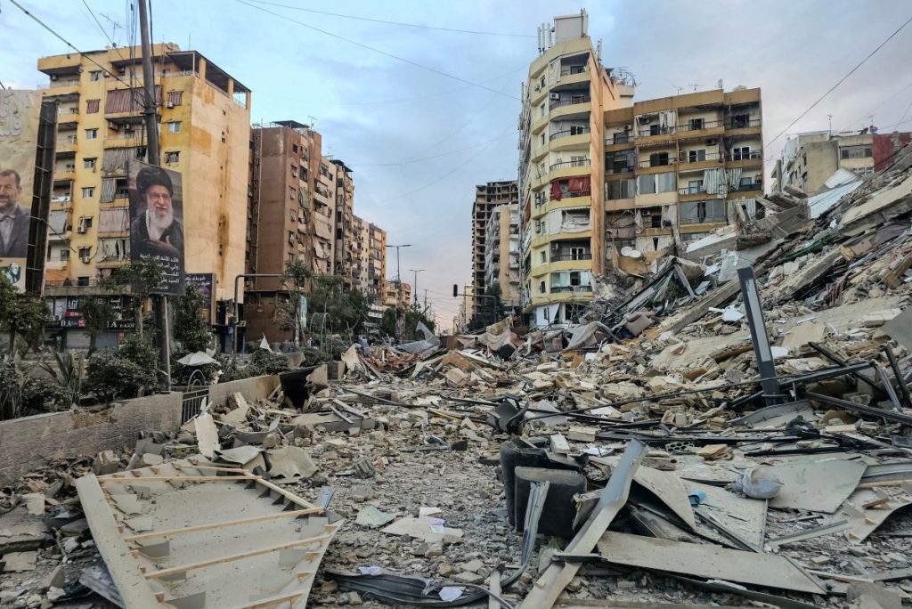 A photograph shows a portrait of Irans slain supreme leader Ayatollah Ali Khamenei and the rubble of a destroyed building at the site of an overnight Israeli airstrike in Beiruts southern suburbs on March 28, 2026. Israel's military renewed its attacks on Beirut's southern suburbs on March 27, saying it was targeting Hezbollah infrastructure, as the Iran-backed group said the foes had clashed directly in the country's south. (Photo by AFP) /