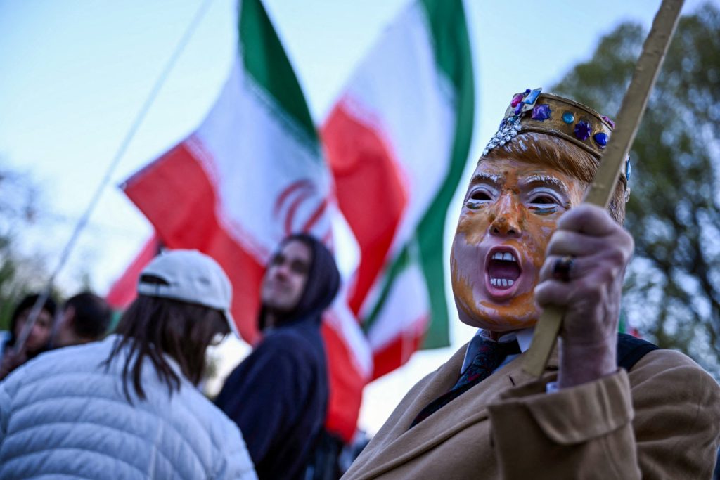 A demonstrator, wearing a mask depicting US President Donald Trump, participates in a protest against US military action in Iran near the White House in Washington, DC, on April 7, 2026. On April 7, US President Donald Trump warned that "a whole civilization will die" in Iran if the country does not heed his midnight cutoff to open the Strait of Hormuz, as Tehran reported US-Israeli attacks on its infrastructure were already underway. (Photo by Brendan SMIALOWSKI / AFP)