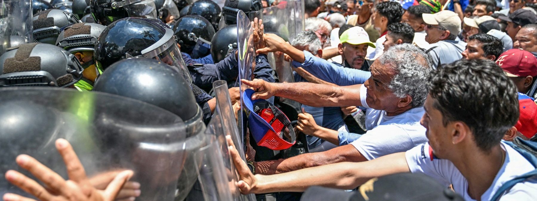 Opponents to the government of Venezuelan interim President Delcy Rodriguez confront the police as they demonstrate in demand of salary and pension raises in Caracas on April 9, 2026. (Photo by Juan BARRETO / AFP)