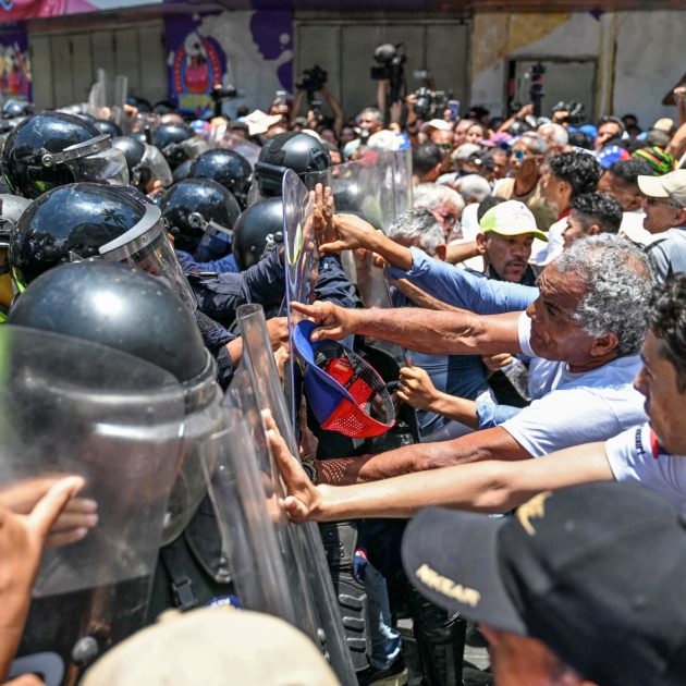 Opponents to the government of Venezuelan interim President Delcy Rodriguez confront the police as they demonstrate in demand of salary and pension raises in Caracas on April 9, 2026. (Photo by Juan BARRETO / AFP)