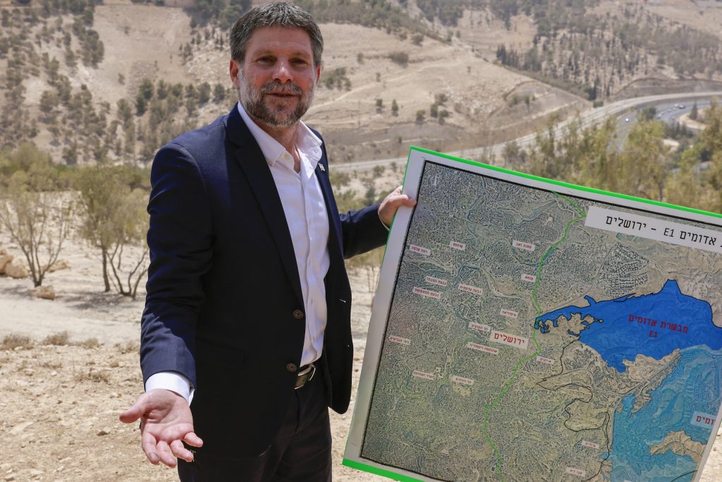 Israeli far-right Finance Minister Bezalel Smotrich holds a map of an area near the settlement of Maale Adumim, a land corridor known as E1, outside Jerusalem in the occupied West Bank, on August 14, 2025, after a press conference at the site. Israel's finance minister on August 14 backed plans to build 3,400 homes in a contentious area of the occupied West Bank, calling for the territory's annexation in response to several countries announcing plans to recognise a Palestinian state. (Photo by Menahem Kahana / AFP)