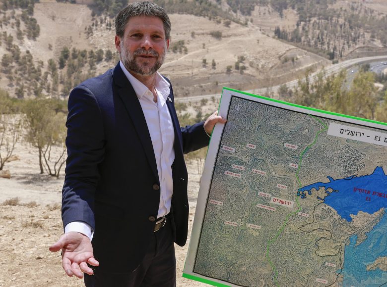 Israeli far-right Finance Minister Bezalel Smotrich holds a map of an area near the settlement of Maale Adumim, a land corridor known as E1, outside Jerusalem in the occupied West Bank, on August 14, 2025, after a press conference at the site. Israel's finance minister on August 14 backed plans to build 3,400 homes in a contentious area of the occupied West Bank, calling for the territory's annexation in response to several countries announcing plans to recognise a Palestinian state. (Photo by Menahem Kahana / AFP)