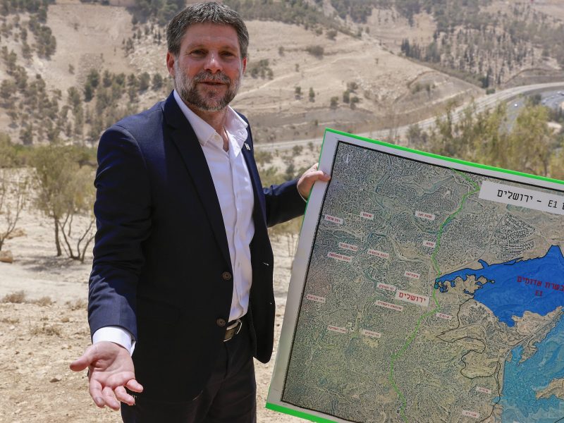 Israeli far-right Finance Minister Bezalel Smotrich holds a map of an area near the settlement of Maale Adumim, a land corridor known as E1, outside Jerusalem in the occupied West Bank, on August 14, 2025, after a press conference at the site. Israel's finance minister on August 14 backed plans to build 3,400 homes in a contentious area of the occupied West Bank, calling for the territory's annexation in response to several countries announcing plans to recognise a Palestinian state. (Photo by Menahem Kahana / AFP)
