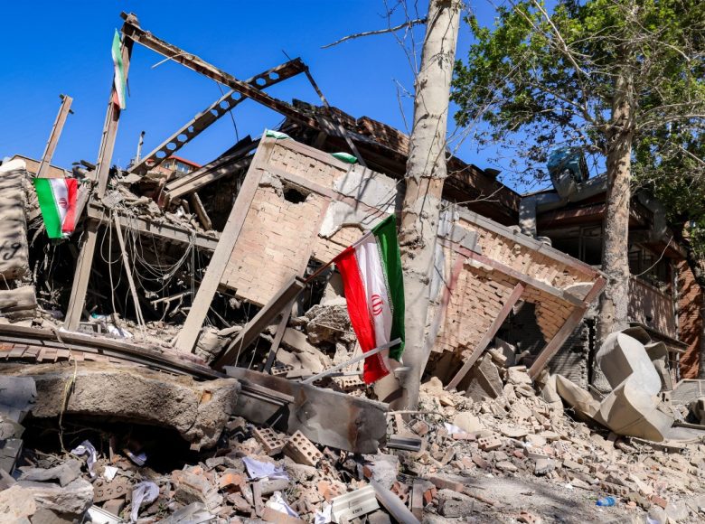 Iranian national flags are placed by the rubble of a collapsed building following strikes at Sharif University of Technology in Tehran on April 7, 2026. Gas supply was restored on April 6 after being cut in parts of Tehran following an attack in the early hours on a gas pressure reduction station and metering facilities at Sharif University of Technology, causing a leak. (Photo by ATTA KENARE / AFP) /