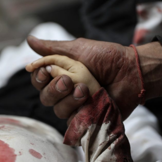 EDITORS NOTE: Graphic content / A relative holds the hand of three-year-old Yahya al-Malahi, who was killed in an Israeli strike ahead of her funeral in Gaza City on April 14, 2026. Gaza's civil defence agency said on April 14 four people, one of them a toddler, were killed in an Israeli strike in the northern part of the Palestinian territory. Violence continues to grip the war-torn Gaza Strip despite a ceasefire which came into effect on October 10, with both Israel and Hamas regularly accusing each other of violations. (Photo by Omar AL-QATTAA / AFP)