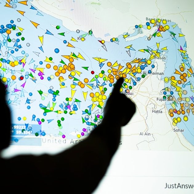 A photo illustration taken in Nicosia on May 4, 2026, shows a person in front of a large screen displaying vessel movements in the Strait of Hormuz on a ship-tracking website. Iran's navy fired 'warning shots' at US warships in the Strait of Hormuz on May 4, state media said, after the American military sent cruisers into the Gulf as part of a plan to help trapped commercial vessels leave. Earlier, US President Donald Trump had announced a plan to guide ships from neutral countries out of the Gulf, saying it was a humanitarian effort to help their stranded crews. (Photo by AFP)