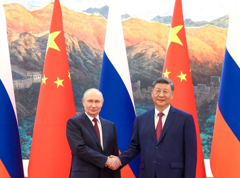 In this pool photograph distributed by the Russian state agency Sputnik, Russia's President Vladimir Putin (L) shakes hands with China's President Xi Jinping during a meeting in Beijing on May 20, 2026. (Photo by Maxim Stulov / POOL / AFP)