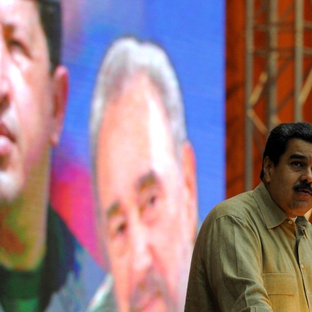 Venezuelan President Nicolas Maduro delivers a speech at the XII Anniversary of the Bolivarian Alliance for the Peoples of Our America (ALBA) at the Convention Palace in Havana, on December 14, 2016, in front of a poster of the late Venezuelan and Cuban leaders Hugo Chavez and Fidel Castro. (Photo by YAMIL LAGE / AFP)