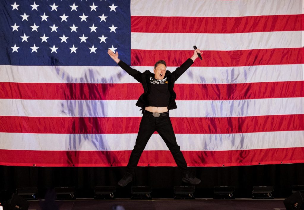 Tesla and SpaceX CEO Elon Musk jumps on stage as he arrives to speak at a town hall event hosted by America PAC in support of former US President and Republican presidential candidate Donald Trump at the Greater Philadelphia Expo Center in Oaks, Pennsylvania, on October 18, 2024. Musk is holding several events in the key swing-state of Pennsylvania in support of former US President and Republican presidential candidate Donald Trump. (Photo by RYAN COLLERD / AFP)