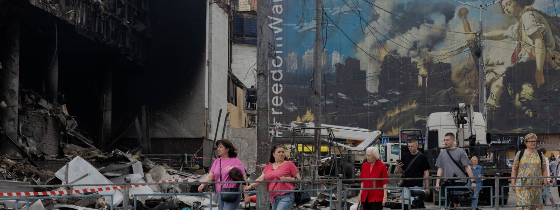Local residents walk by a damaged shopping center following Russian strikes in Kyiv on May 25, 2026, amid the Russian invasion of Ukraine. (Photo by Tetiana DZHAFAROVA / AFP)
