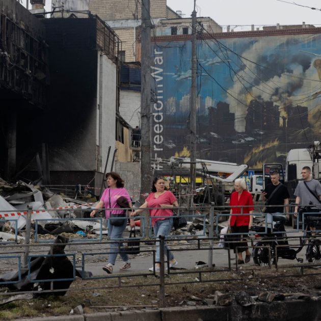 Local residents walk by a damaged shopping center following Russian strikes in Kyiv on May 25, 2026, amid the Russian invasion of Ukraine. (Photo by Tetiana DZHAFAROVA / AFP)