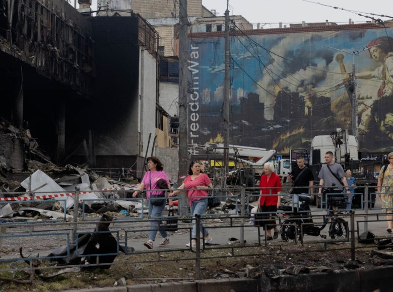 Local residents walk by a damaged shopping center following Russian strikes in Kyiv on May 25, 2026, amid the Russian invasion of Ukraine. (Photo by Tetiana DZHAFAROVA / AFP)