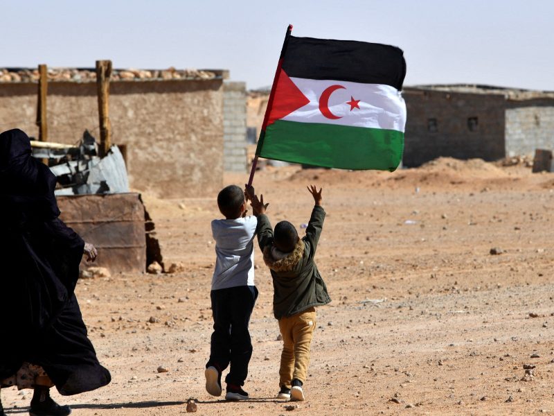 A child raises the flag of the Sahrawi Arab Democratic Republic (SARD) during celebrations marking the 47th anniversary of the declaration of national unity of the Sahrawi people, in the Aousserd refugee camp on the outskirts of the southwestern Algerian city of Tindouf, on October 12, 2022. (Photo by Ryad KRAMDI / AFP)