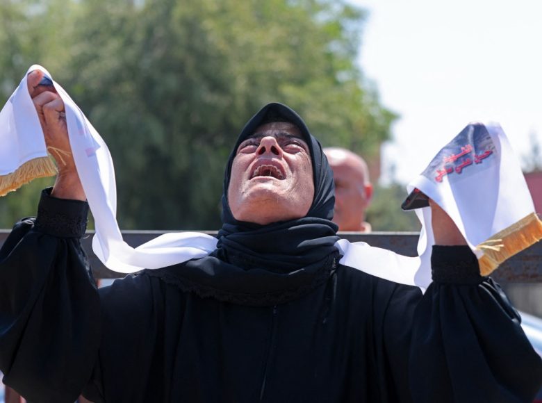 EDITORS NOTE: Graphic content / A mourner weeps during the funeral of three Lebanese Civil Defense members who were killed in an Israeli airstrike, in the southern city of Tyre on April 30, 2026. The Lebanese health ministry said Israeli strikes on April 28 killed eight people, including civil defence rescuers, and wounded two soldiers in the country's south, despite a fragile ceasefire. (Photo by MAHMOUD ZAYYAT / AFP)