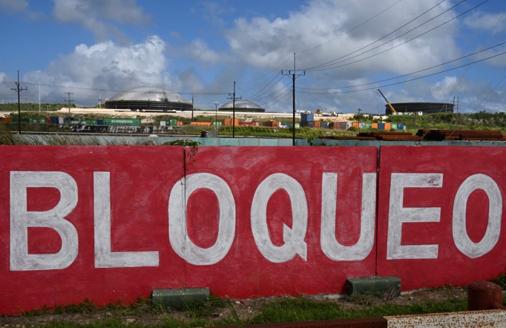 This view shows a mural reading blockade, with several fuel storage tanks in the background in the industrial zone of Matanzas, Cuba, on March 31, 2026. (Photo by YAMIL LAGE / AFP)